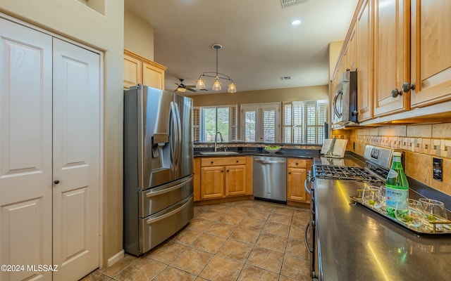 kitchen with ceiling fan, sink, backsplash, decorative light fixtures, and appliances with stainless steel finishes