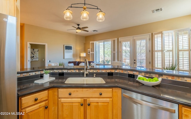 kitchen featuring ceiling fan, sink, french doors, pendant lighting, and appliances with stainless steel finishes