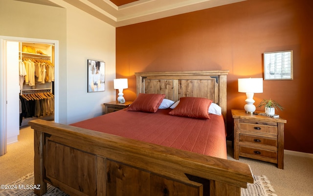 bedroom featuring light colored carpet, a walk in closet, and a closet