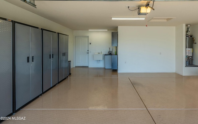 garage featuring gas water heater, a garage door opener, and sink