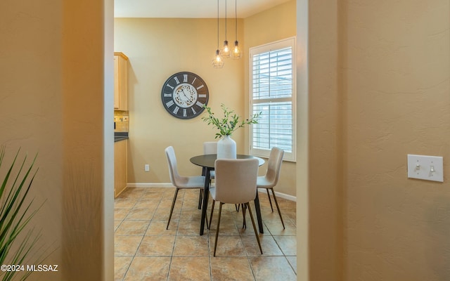 tiled dining area with a chandelier