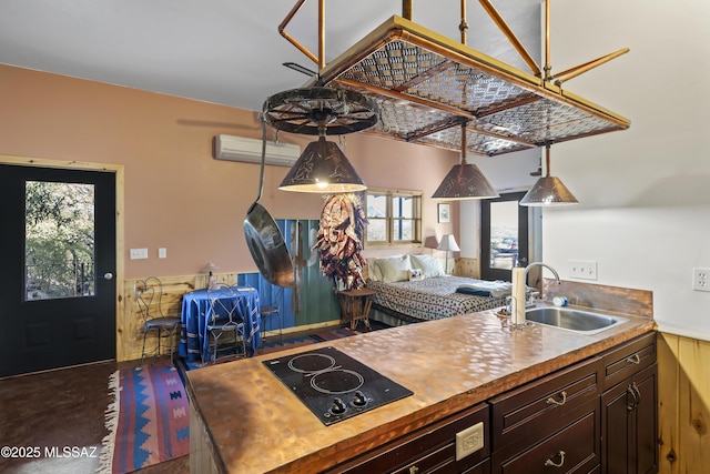 kitchen with an AC wall unit, sink, plenty of natural light, and black electric stovetop