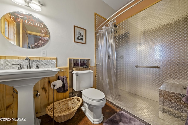 bathroom with a shower with curtain, toilet, and wooden walls