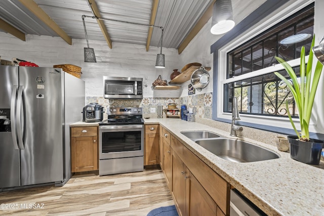 kitchen featuring beam ceiling, sink, light hardwood / wood-style floors, and appliances with stainless steel finishes