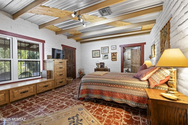 bedroom with beamed ceiling and brick wall