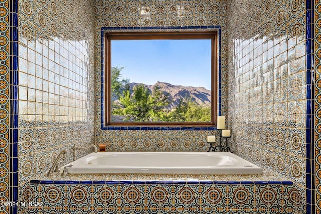 bathroom featuring a mountain view and a relaxing tiled tub