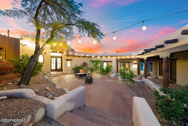 patio terrace at dusk featuring french doors and an outdoor fire pit