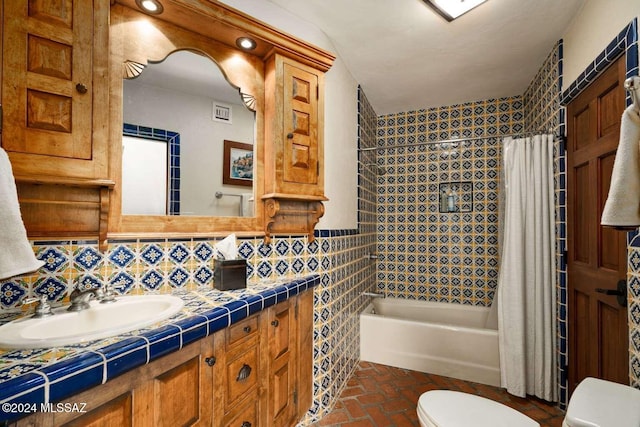 full bathroom with vanity, shower / bath combination with curtain, tile walls, and toilet