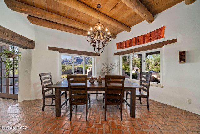 dining space with beam ceiling, wood ceiling, plenty of natural light, and a high ceiling