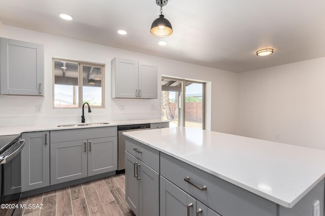 kitchen featuring gray cabinetry, pendant lighting, sink, and appliances with stainless steel finishes