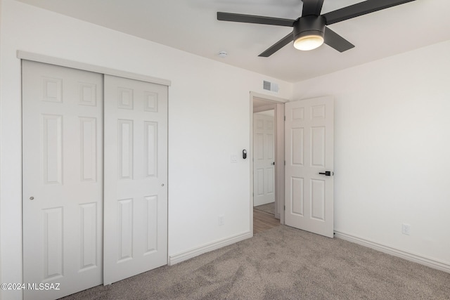 unfurnished bedroom with light carpet, a closet, and ceiling fan