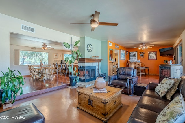 living room featuring a tile fireplace and concrete flooring