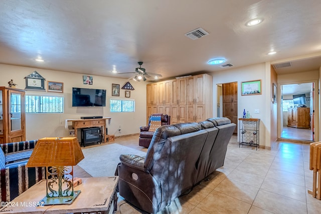 living room with a fireplace, light tile patterned floors, and ceiling fan