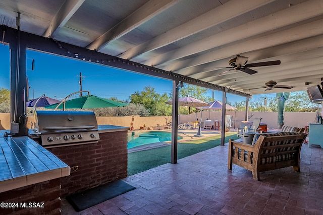 view of patio featuring a grill, a fenced in pool, and exterior kitchen