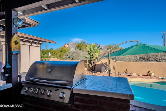 view of patio / terrace featuring a grill and a pool