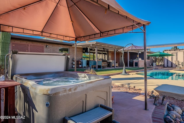 view of patio featuring a swimming pool with hot tub