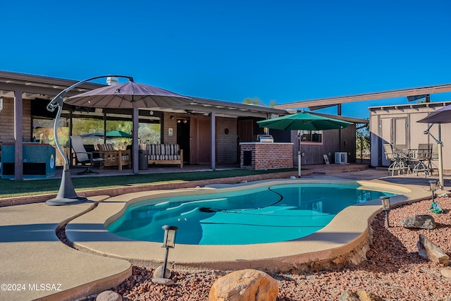 view of pool featuring a patio, central AC, and a storage unit