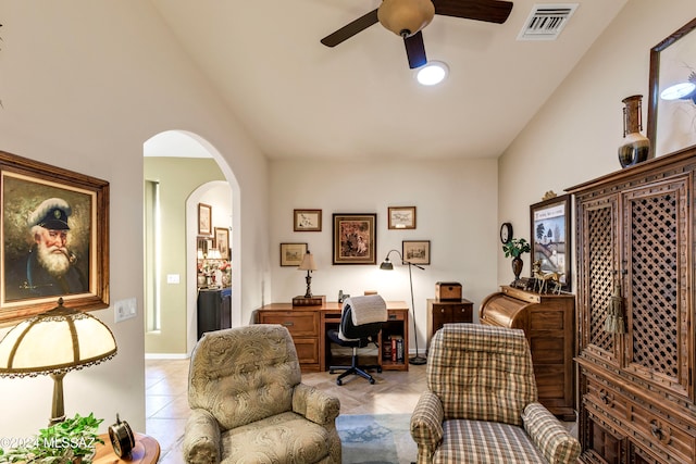 interior space featuring ceiling fan, light tile patterned floors, and vaulted ceiling