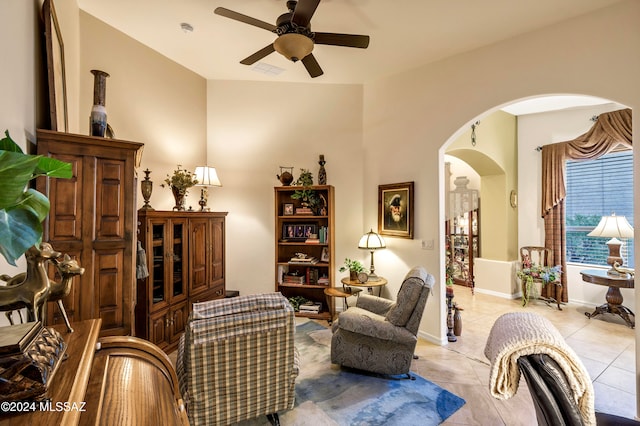 living area with light tile patterned floors and ceiling fan