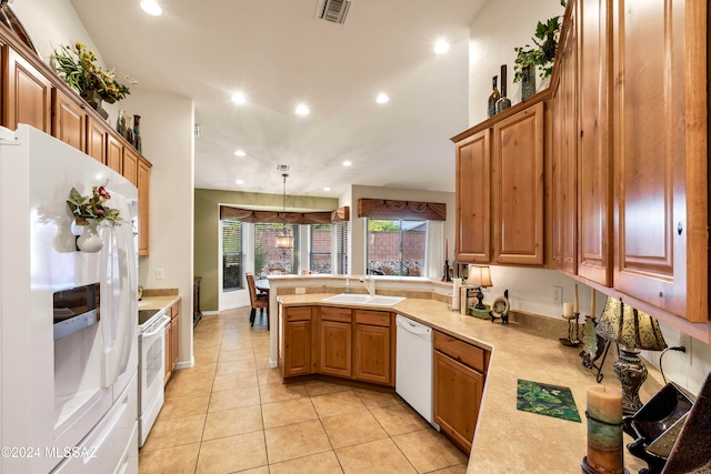 kitchen featuring sink, kitchen peninsula, pendant lighting, white appliances, and light tile patterned floors