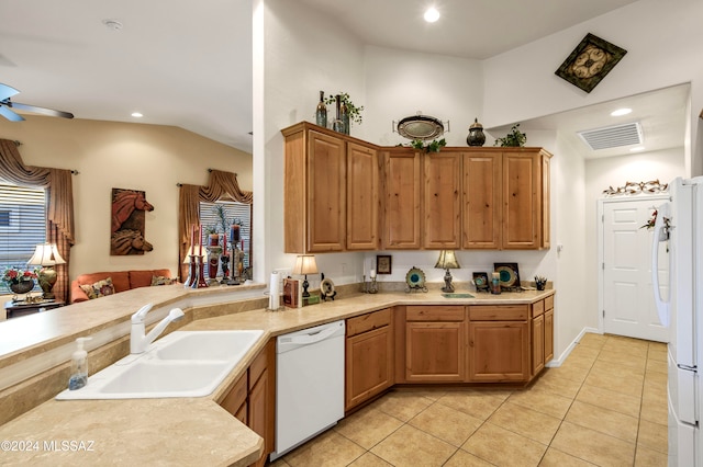 kitchen with white appliances, sink, ceiling fan, light tile patterned floors, and kitchen peninsula