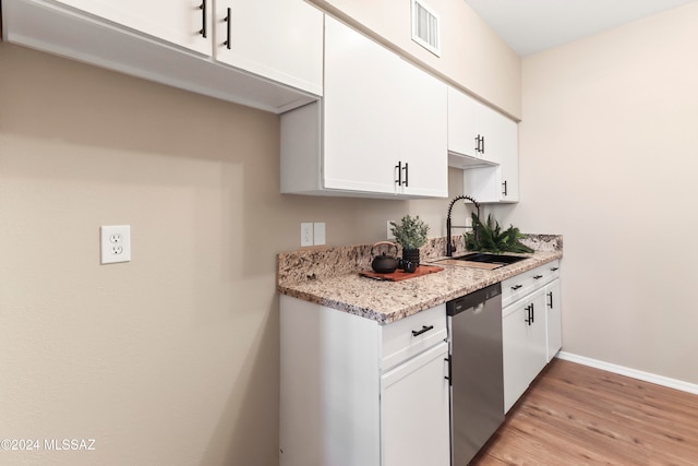 kitchen with light stone countertops, white cabinetry, sink, stainless steel dishwasher, and light hardwood / wood-style floors