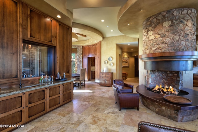 bathroom with vanity, a stone fireplace, and ceiling fan