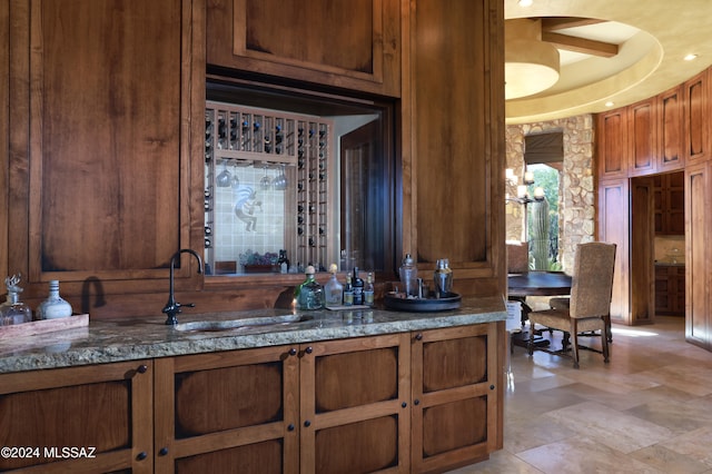 bar with sink and dark stone counters