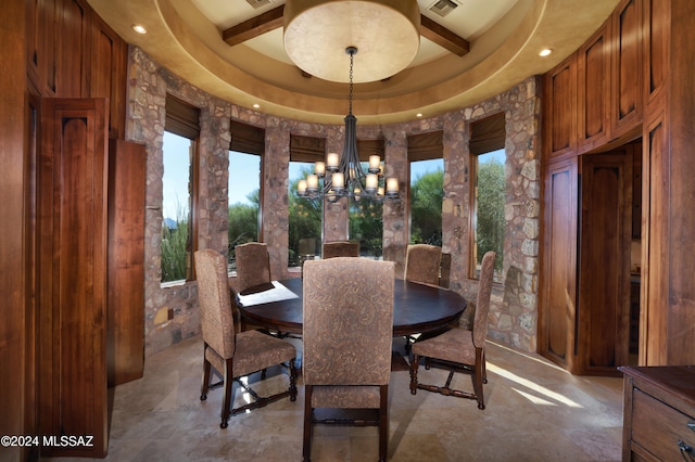 dining space with a raised ceiling, plenty of natural light, and a notable chandelier