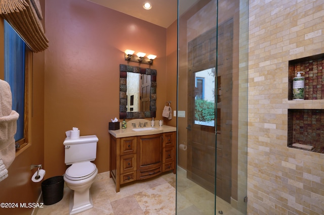 bathroom featuring vanity, a shower with shower door, and toilet