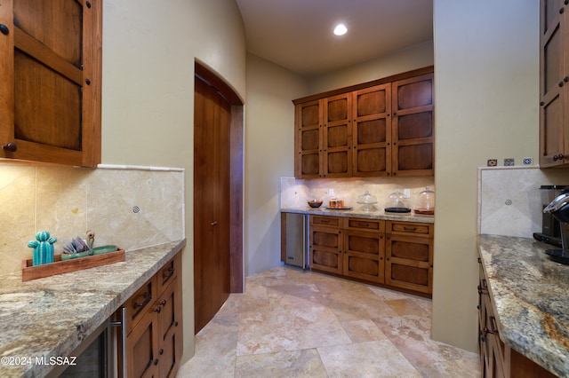 kitchen featuring decorative backsplash and light stone counters