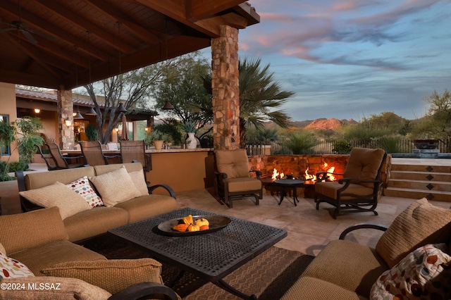 patio terrace at dusk featuring an outdoor living space with a fire pit