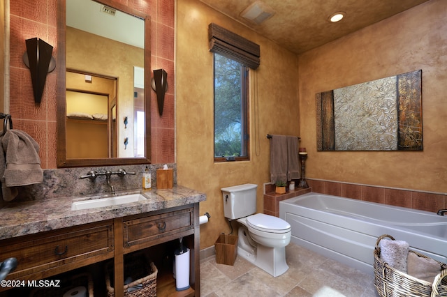 bathroom with vanity, toilet, and a tub