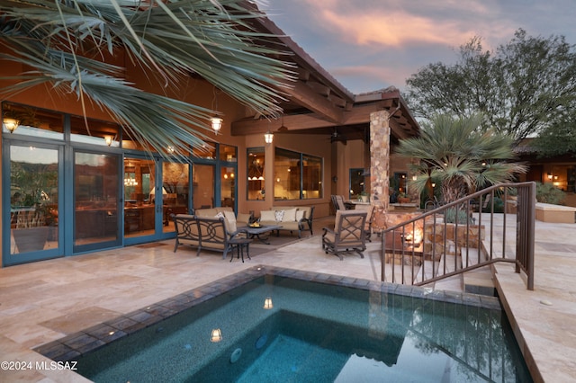 pool at dusk with an outdoor living space, ceiling fan, a patio area, and a jacuzzi