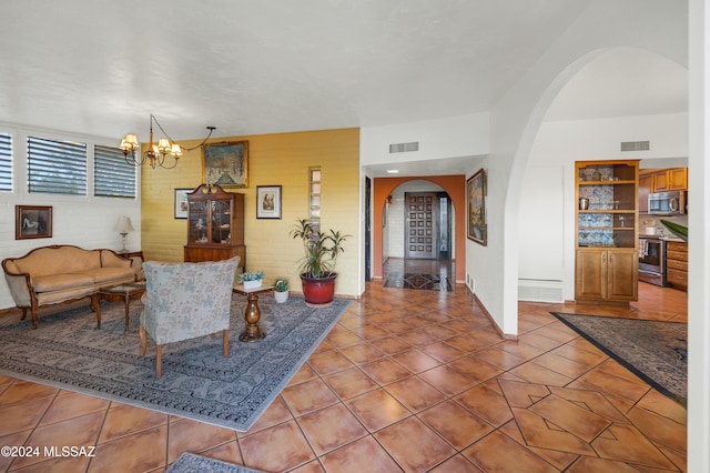 tiled living room with a notable chandelier