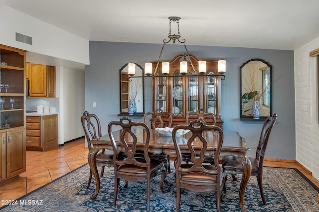 tiled dining space with a chandelier