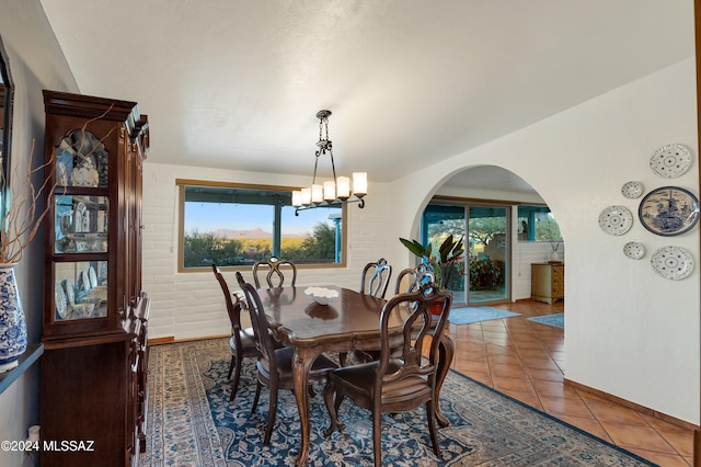 tiled dining space with an inviting chandelier