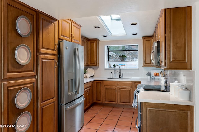 kitchen with decorative backsplash, sink, light tile patterned floors, and appliances with stainless steel finishes