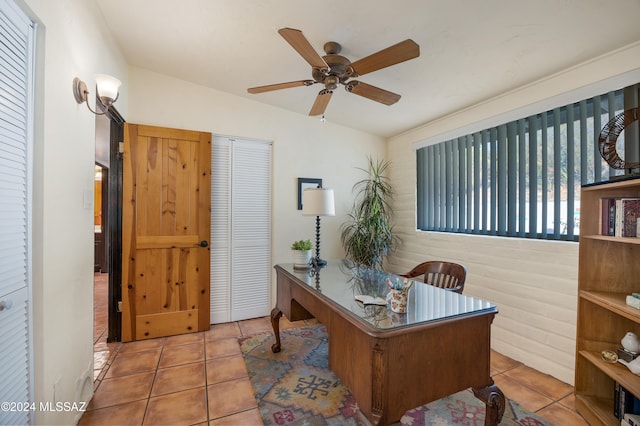 tiled home office featuring ceiling fan