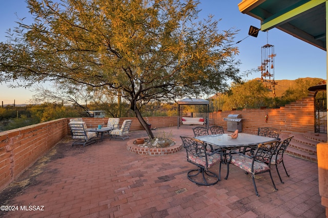 patio terrace at dusk with area for grilling and an outdoor hangout area