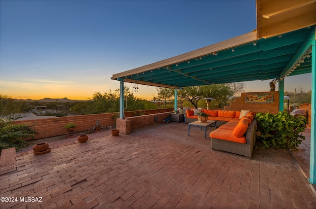 patio terrace at dusk featuring an outdoor living space