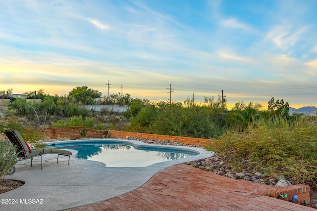 pool at dusk with a patio