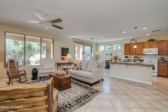 living room with light tile patterned floors, ceiling fan, and sink