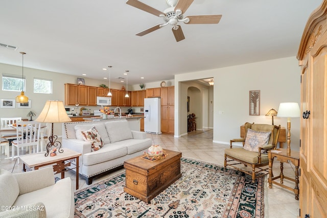 tiled living room with ceiling fan and sink