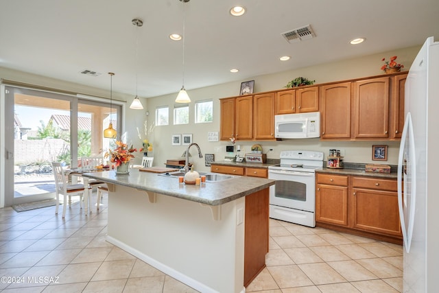 kitchen featuring sink, decorative light fixtures, white appliances, a kitchen island with sink, and light tile patterned flooring