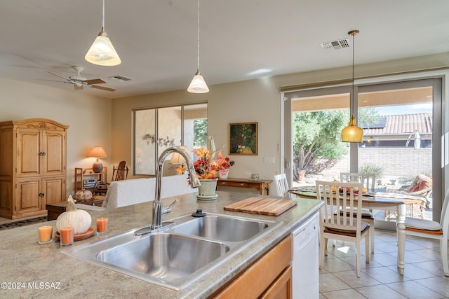 kitchen with ceiling fan, dishwasher, sink, decorative light fixtures, and light tile patterned floors