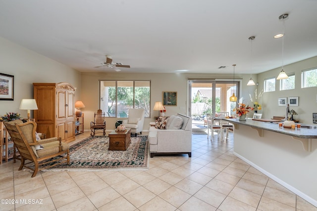 tiled living room featuring ceiling fan, a healthy amount of sunlight, and sink