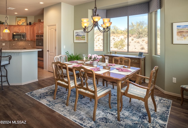 dining room with an inviting chandelier and dark wood-type flooring