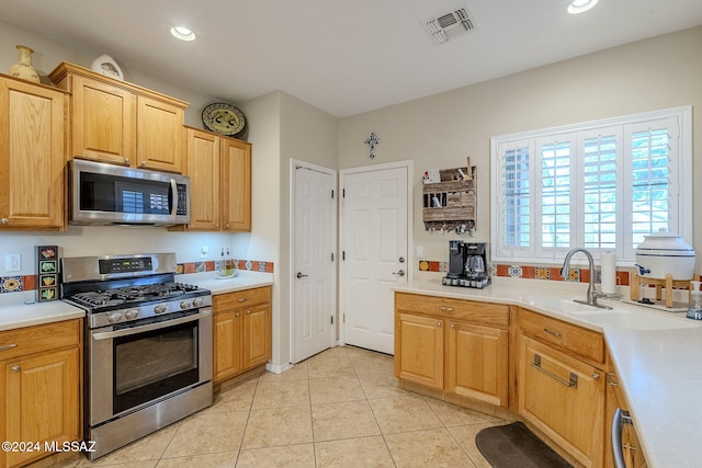 kitchen with light tile patterned flooring, sink, and stainless steel appliances