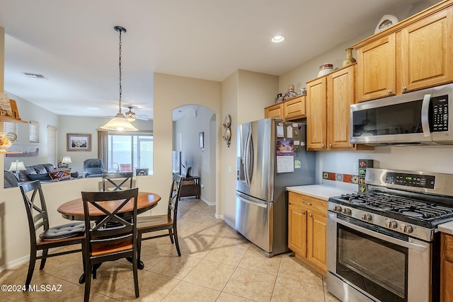 kitchen with pendant lighting, light tile patterned flooring, and appliances with stainless steel finishes